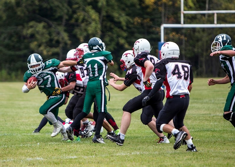 Athabasca Pacers player Nathaniel Borys tries to carry the ball past a pack of Westlock Thunderbirds Sept. 8. The Thunderbirds won the first game of the season, with a final