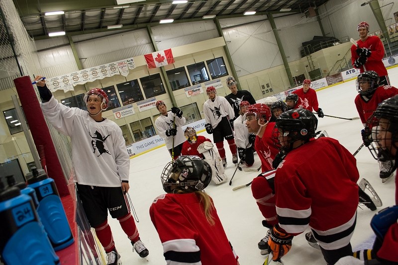 Augustana Viking Lukas Biensch walks his team and Athabasca Hawks Pee Wee hockey players through a drill during their group practice Sept. 10 while at the Athabasca College