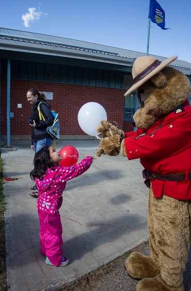 Storm Gladue gives the RCMP Safety Bear a poke at the Citizens on Patrol barbecue Sept. 16.