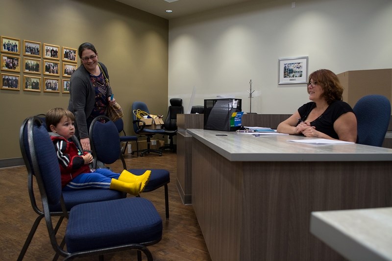 Kristina Heggs (left) carries her seven-week-old daughter, while her son two-year-old Arian gets his first taste of municipal democracy from deputy returning officer Corrine