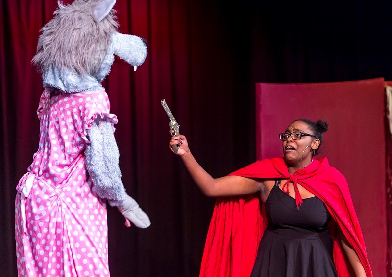 Rufaro Madamobe pulls a gun on the wolf (Cassidy Siwiski) while playing Little Red Riding Hood during Edwin Parr Composite School&#8217;s Nov. 2 showing of The Brothers Grimm 