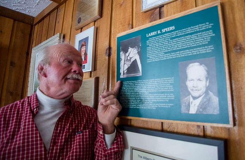 Larry Speers, retired Athabasaca County councillor and local educator, examines his University of Alberta Sports Wall of Fame induction plaque, with a photo of him competing