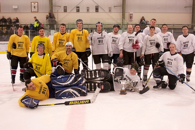 The Athabasca and Boyle emergency services hockey teams group together in centre ice at the Athabasca Regional Multiplex after the sixth annual Emergency Services Charity