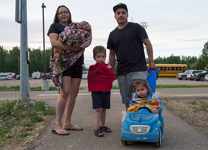  Roxy Atkinson and Riley Cardinal stand with one-year-old Skyley Atkinson, three-year-old Shylee Atkinson (on blue car) and four-year-old Cashius Atkinson (in red) May 30.