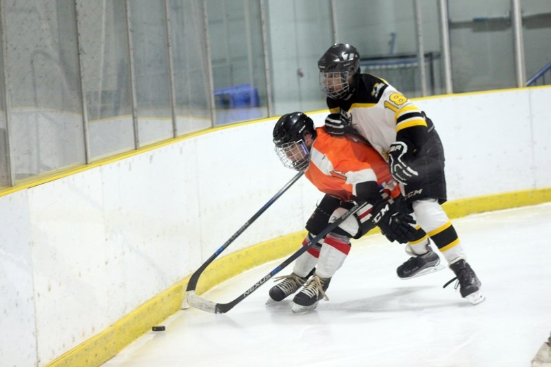Steelers player Jona Cisse edges out a Maskwacis player for control of the puck during the Jan. 5 game that ended 6-0 for Barrhead.