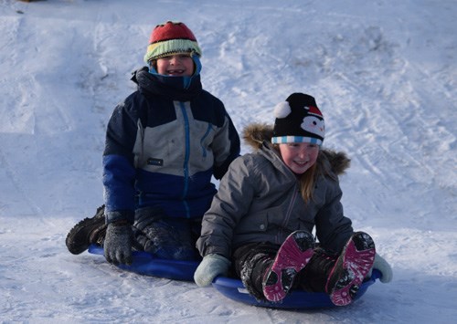 Nicholas Kliparchuck (back) and Halee Demone, both in Grade 2, take advantage of a small hill on the playground of Dunstable School during a January 22 recess