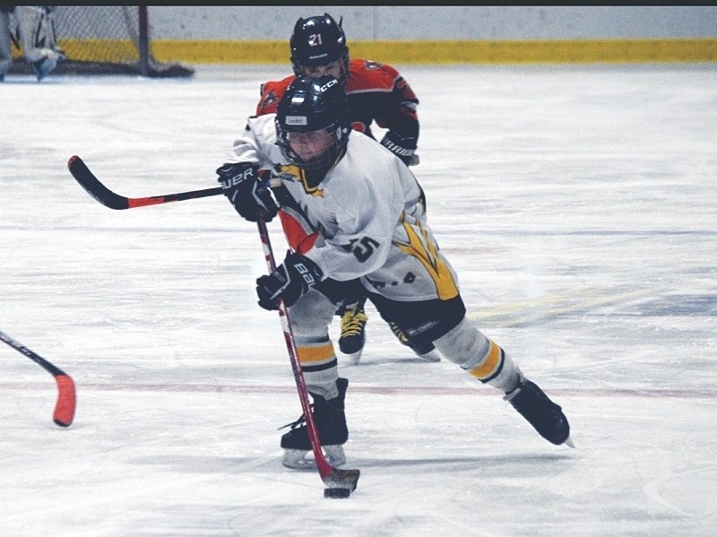 Elks player Locke Montegomery controlling the puck with speed in opposition zone.