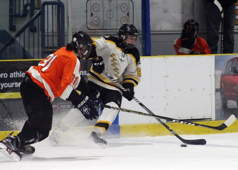 Barrhead Steelers player Brendan Bujold wrestles the puck away from a Mackwacis Hawks forward, during a regular season game Feb. 23 that ended 9-1 for Barrhead. Bujold scored 