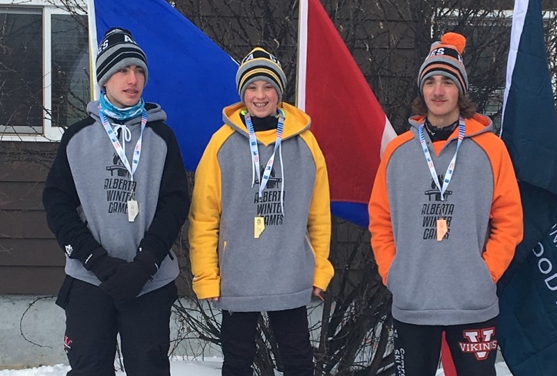 Henrik Quintilio (centre) receives his gold meal in the individual biathlon.