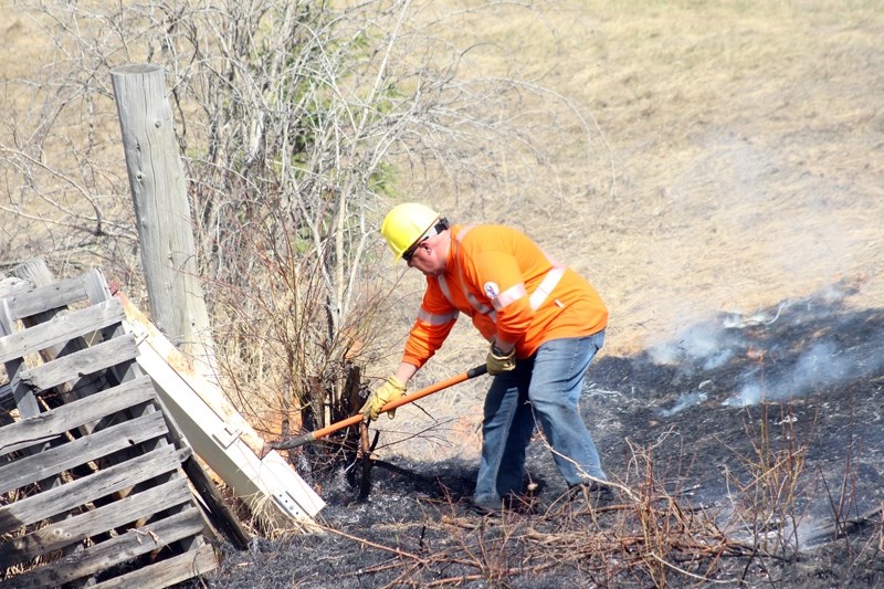 Valard health and safety supervisor Jim Friesen uses a shovel to combat a grassfire on Highway 33 and Range Road 53 May 4, being one of the first people on scene.