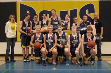 Flanked by coaches Alix deBeaudrap (left) and Dave Mueller (right), the BCHS senior boys Gryphons celebrate knocking off the R.F. Staples Thunderbirds 62-37 to win their home 