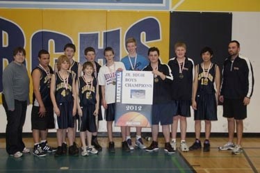 Champions: The Senior Jaguars display their gold medals and the banner proclaiming them Junior High Boys Champions. Pictured far right is their coach Colin Erickson.