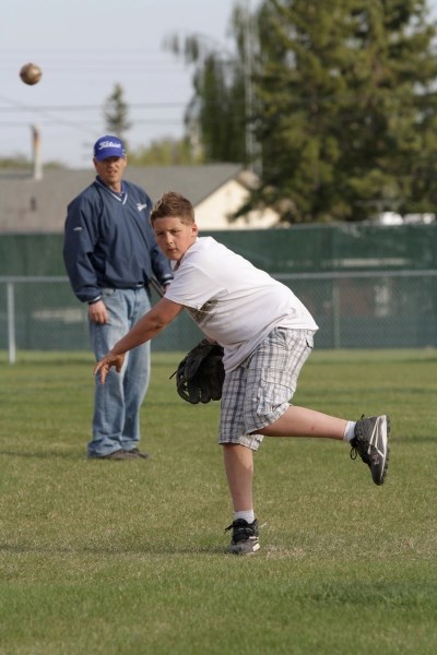 Under the watchful eyes of the Pee Wee Yankees&#8217; coaching staff, Tanner Whiting works out in a catching and throwing drill on May 15. The Yankees started their season by 