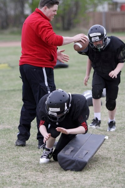 Town peace officer and coach Jonathon Kerr helps run a drill at the Barrhead Raptors&#8217; May 16 practice. Players had to tackle the dummy and chase down a fumble.
