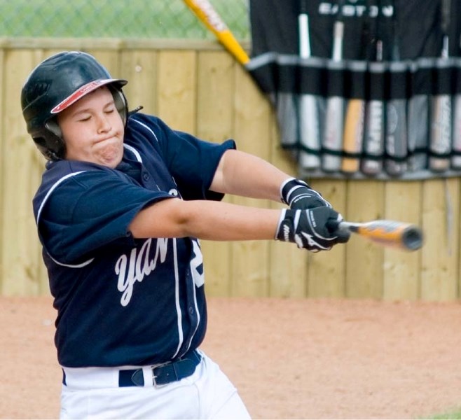 Blake Busch swings at a fast pitch, connecting with the ball and making it to first base.