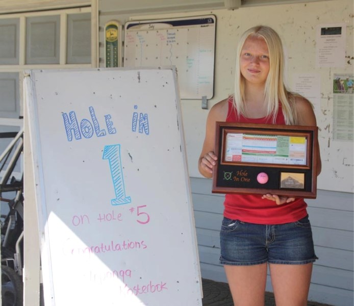 Iron lady: Topanga Kosterbok displays a hole-in-one plaque at the Paddle River golf club last Thursday.