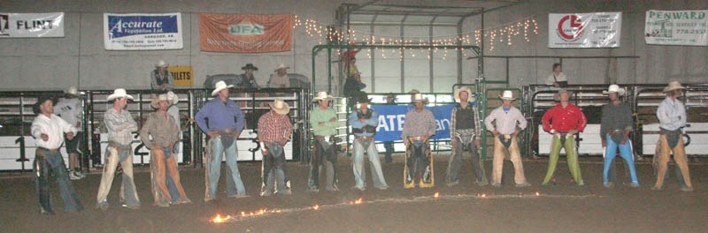 Ready for action: In the darkness of the Sangudo arena, cowboys line up behind an arc of fire on Saturday evening. Once the flames were doused, a full house was treated to