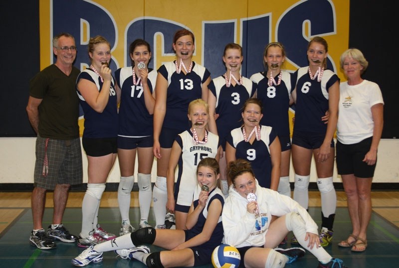 Taste of gold: Barrhead &#8216;s junior Gryphons girls bite into their gold medals after winning the JV volleyball tournament on Saturday. They are pictured with coach Gayle