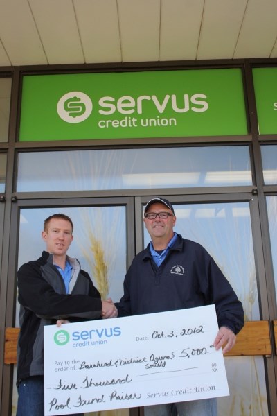 Servus with a smile: Servus Credit Union branch manager Jason McElroy (left) presents a $5,000 cheque to Shannon Carlson.