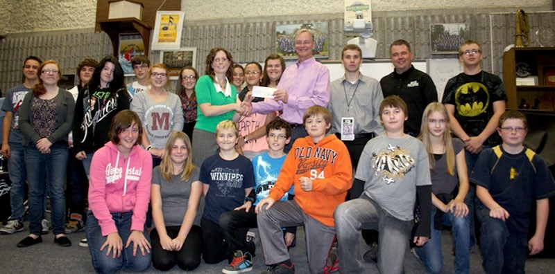 Helping out: Newcap Radio Alberta program director for the Alberta NW division, Rob Alexander, presents the $4,000 cheque to BCHS band director Kerri-Lee Kostiw. Next to