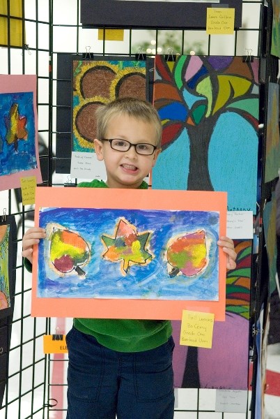 Six-year-old Bo Cerny holds up his fall leaves artwork at the Annual Fall Fine Arts Show Saturday, Oct. 20. Bo created the work with painted paper towel leaves on paper.