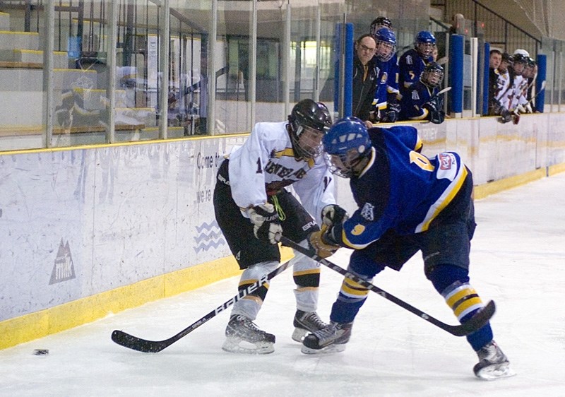 Teammates on the bench watch intently as Renegades player Nicholas Murrell fights off a Leduc opponent in a fight for the puck during their game Feb. 2.