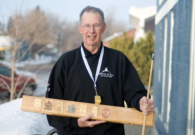 Bob Milligan holds the wooden case where he keeps his cues, which he has covered with medals from previous wins in snooker and hockey at the Winter Games. The Sangudo man can 