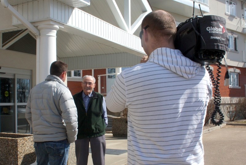Man of the moment: Ninety-two-year-old Doug Gibb talks to Global Edmonton reporter Shane Jones outside Klondike Place last Wednesday. Holding the camera is Cliff Harris, who