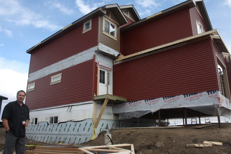Northplex president Frank Deys seen by the two-storey home with a modular, fully finished basement. Northplex plans an open house on June 14 and 15, unveiling the basement