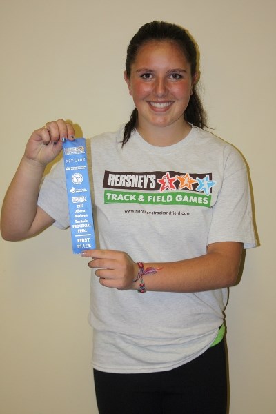 Shae Borle shows off the blue ribbon she received after her record-breaking softball throw at the meet in Edmonton.