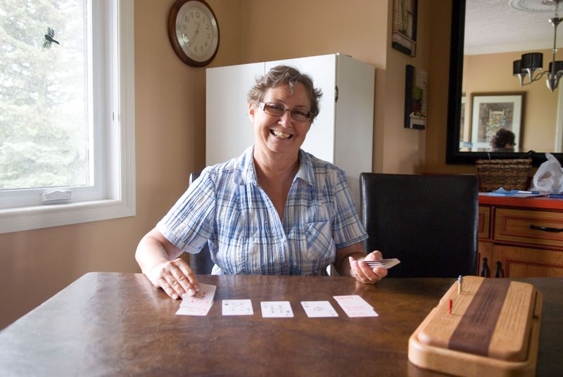 Gayle Schneider sits at her kitchen table every morning and plays a solitaire version of cribbage.