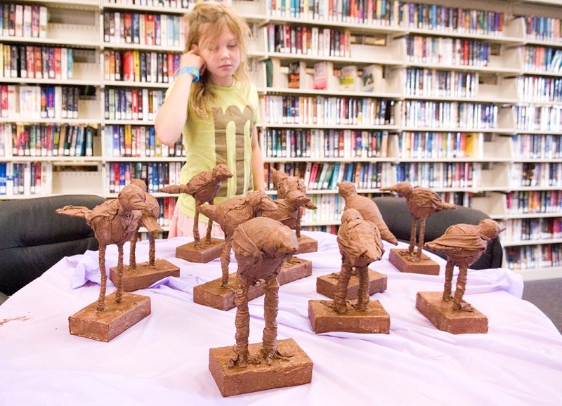 Aleara Kennings, 11, looks over a group of paverpol bird sculptures, which would later be painted and decorated with eyes and feathers.