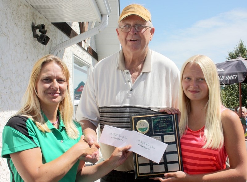 Tournament winners Charlie Hartt and Topanga Kosterbok receive their plaque and prizes from Topanga &#8216;s mom Mariet Kosterbok, Paddle River assistant manager.