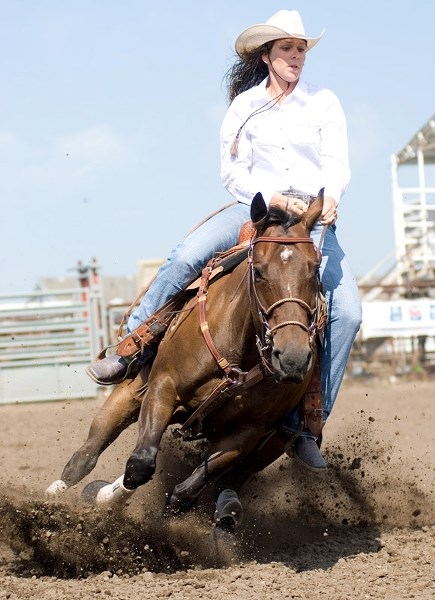 Speeding along, Barrhead cowgirl Kaila Skogstad turns up dirt on her run during the Ladies Barrel Racing event at the Blue Heron Fair rodeo Saturday, Aug. 10. The rodeo was