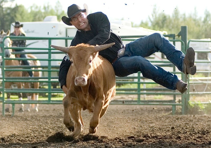 Fort Assiniboine cowboy and rodeo organizer Jason Resch tackles a steer during a steer wrestling event.