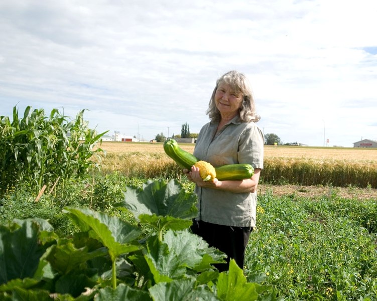 Glenice Wilson holds zuchini from the garden plot she shares with Phyllis Nanninga. After their plot flooded, their garden managed to come back to life.