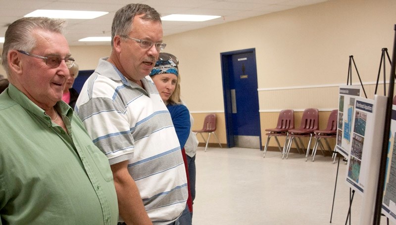 Town councillor Roy Ulmer, Kevin Steves, food store manager at the Co-op, and Carrie McElroy, pharmacist at the Rexall and mother of two young children view the latest three