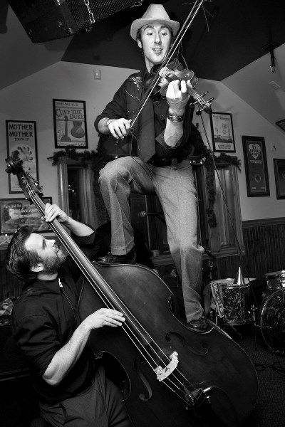 Gordie MacKeeman plays fiddle while balancing on an upright bass played by Thomas Webb. Barrhead music fans can expect a high-energy show.