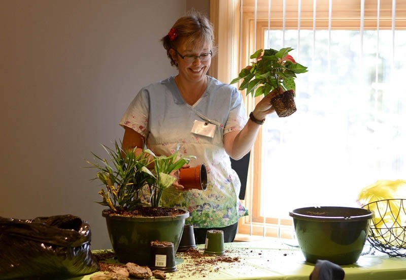Inge Dehert of Southside Greenhouses, presenter for session Planter Gardening, prepares to demonstrate potting multiple small plants in one planter.