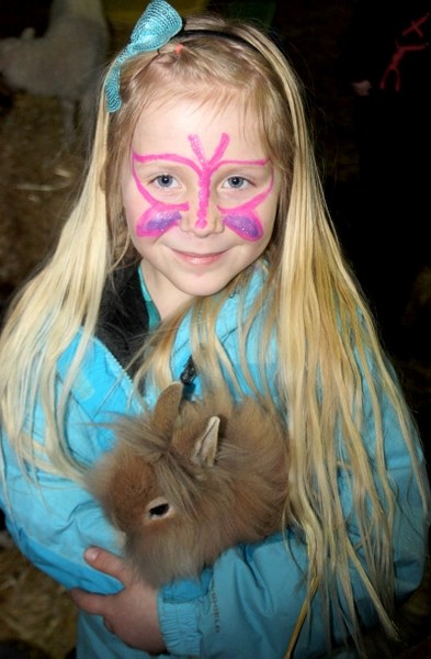 Six-year-old Lexi Velkow cuddles a rabbit at the petting zoo, which was set up in the Zamboni section of the Agrena. The petting zoo was one of F4 &#8216;s new attractions