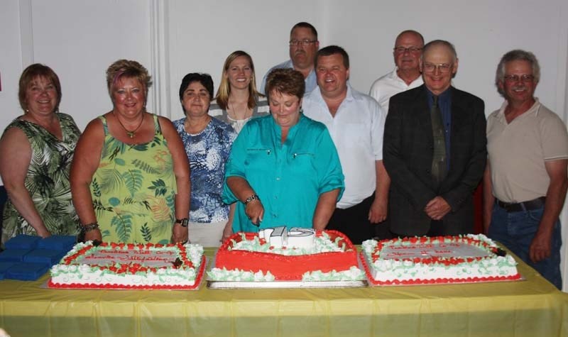 Past and present members of the board of directors for the Pembina West Co-op cut the anniversary cake at the 75th anniversary celebration of the Barrhead and Mayerthorpe