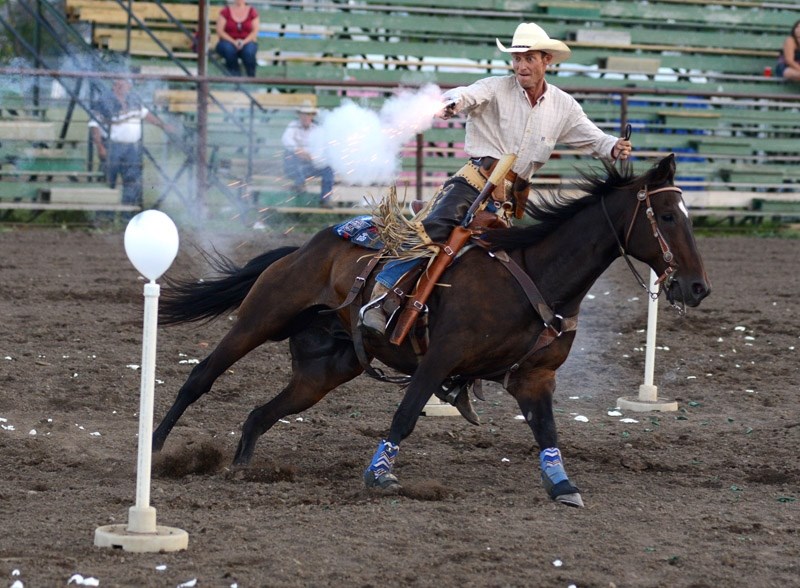 Gary Couch fires his gun at a balloon target during the Mounted Shooters competition at the Blue Heron Fair over the weekend.