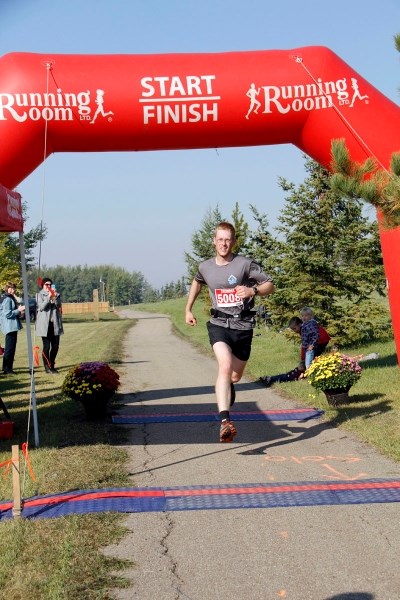 Mark Loogman crosses the finish line, claiming the place as first place men &#8216;s solo.
