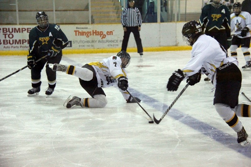 Tanner Whiting dives for the puck in hopes of keeping it out of their end during the game, with the help of Dylan Callihoo.
