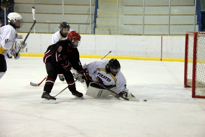 Barrhead Pirates goalie, Ty Steinberg, reaches for the puck, as Cobras &#8216; player, Tanner Kanis attempts to score during the first period of their game on Oct. 18.