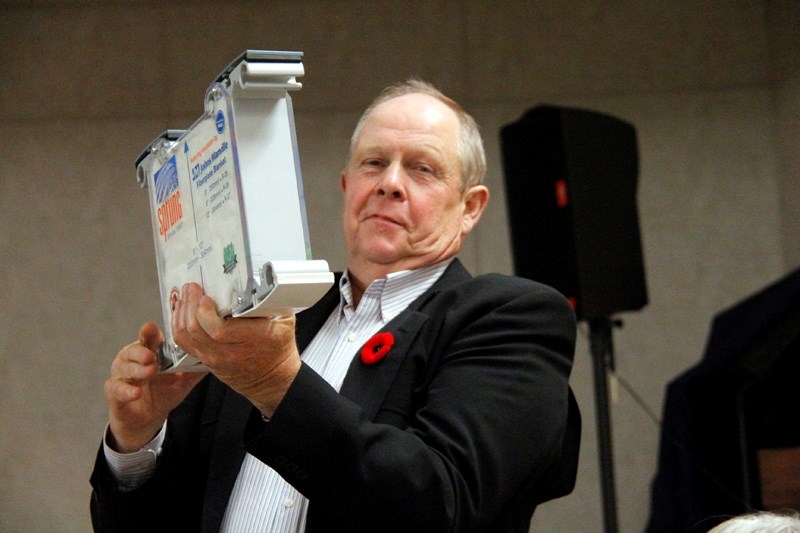 County Reeve Bill Lee shows the crowd a sample piece of the materials used for the structure.