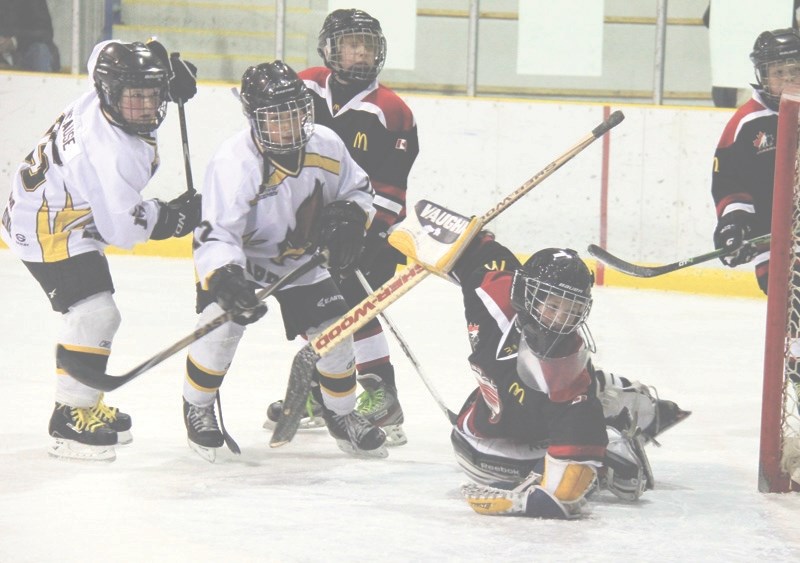 The Barrhead Hawks attempt to score during their second game in the tournament against the Edmonton Brave Raiders. Raiders goalie, Parker Gunn, keeps an eye on the puck as it 