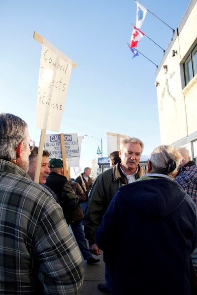 Dale Johnson, Community Lead of the rally, speaks to a woman regarding to matter, sharing his concerns if council were to move forward with the construction of a new county