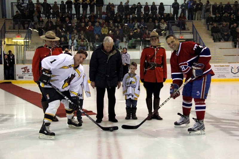 Dale Gummow, player for the Barrhead Old Vets, participates in the honourary puck drop with Gilbert Delrome of the Montreal Canadiens Alumni. Dropping the puck was Fred