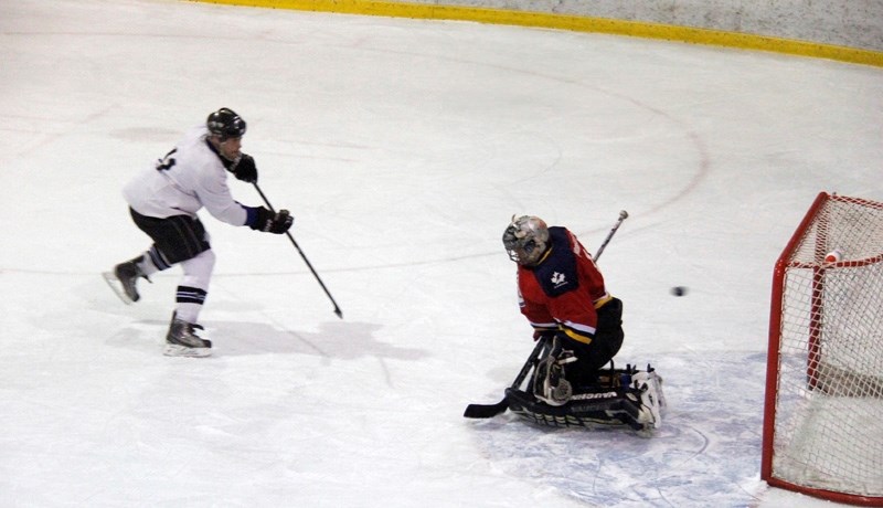 To relinquish their winning title, Barrhead Old Vets player, Tim Schneider, scores a shoot-out goal for the team. In the net for the Linaria Barons is Kurt Wierenga.